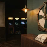 Wooden prize wheel and waiting envelopes in a game room, for the 500 Casino review on provably fair originals and weekend payout pauses