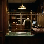 Large leather holdall at a cashier cage with a narrow brass tray, illustrating the Axe Casino review