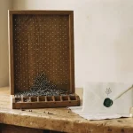 Wooden pegboard with brass pegs and a wax-sealed envelope, illustrating the BC.Game review