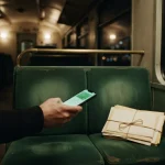 Phone showing a quick payment beside unopened letters on a train, reflecting the BetPlay review