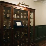 Trophy cabinet with an empty plinth and a sealed envelope, pointing to the BiggerZ review