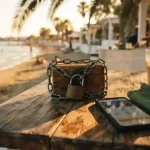 Padlocked coin box and a smartphone on a beach cafe table, illustrating the Coins.Game review