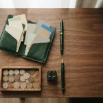 Travel wallet of blank cards and mixed coins on a hotel desk, reflecting the IntellectBet review