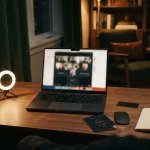 Laptop video call set-up with a face-down passport, reflecting the Irwin review