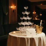 Five-tier tower of empty champagne coupes in a VIP room, illustrating the iWild review