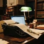 Typewriter with a long contract and a laptop on a clerk